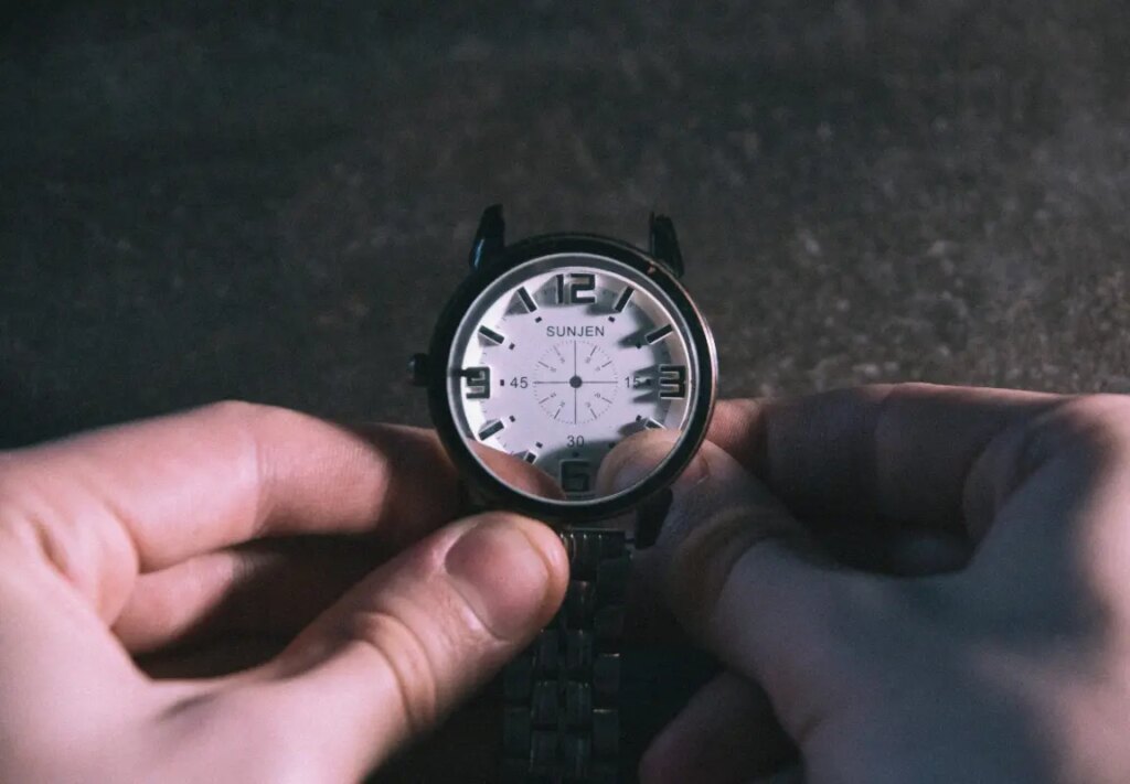 A person holding a watch in their hand